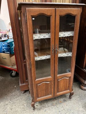 a wooden cabinet with glass doors in a room