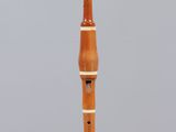 a wooden flute on display on a clear stand