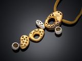a close up of a gold and diamond necklace on a black surface