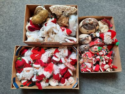deux cartons remplis de décorations de Noël variées posés par terre