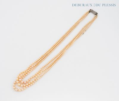 a close up of two strands of pearls on a white surface