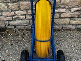 un chariot bleu auquel est fixé un tuyau jaune