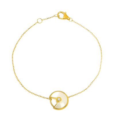 a gold plated bracelet with a white mother of pearl disc
