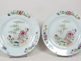 deux assiettes ornées de fleurs et d'oiseaux sur un fond blanc