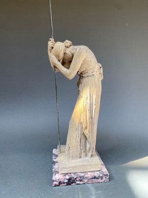 statue d'une femme tenant un drapeau, posée sur un socle en marbre