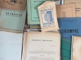 many old books on a table with papers on it