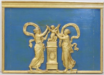 une plaque dorée sur un mur bleu, avec deux femmes