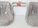 two plastic chairs are wrapped in plastic and ready to be used