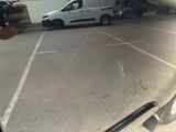a man taking a picture of a car in a parking lot