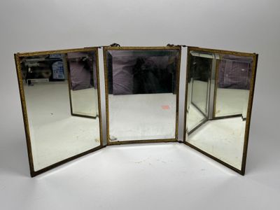 three mirrors with brass frames on a white surface
