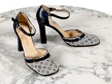 une paire de chaussures à talons hauts noires et blanches posées sur une table en marbre