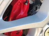 a close up of a red brake on a silver car