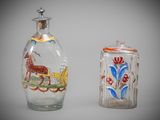 two glass bottles with designs on them sitting next to each other