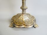 a silver and gold candle holder on a white table