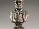 bronze bust of a man with a beard and mustache on a pedestal