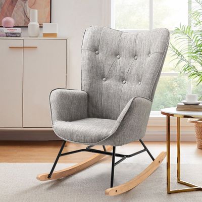 Le fauteuil à bascule gris se trouve à côté d'une table sur laquelle est posée une plante en pot.