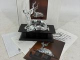 une sculpture en verre représentant un cerf, posée sur une table