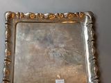 two silver trays with handles and handles on a table