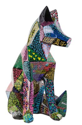 un gros plan sur une sculpture représentant un chien assis sur une surface blanche