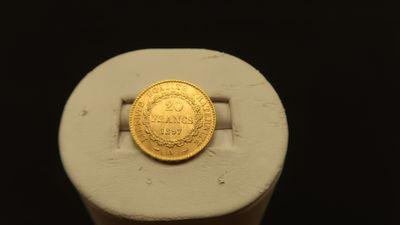 a gold coin sitting on top of a white ring