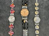 three different watches sitting on top of a table next to each other