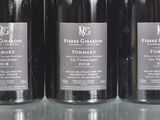 three bottles of wine are lined up on a glass table