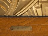 a close up of a gold clock on a wooden table