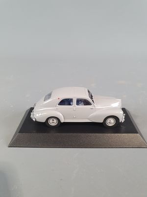 a white toy car on a black base on a table