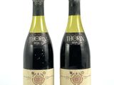 deux bouteilles de vin posées l'une à côté de l'autre sur une surface blanche