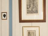 three framed pictures on the wall above a toilet