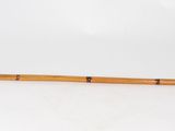 an old wooden stick with a black handle sitting on a white surface