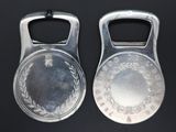 pair of silver bottle openers with a laurel design on them