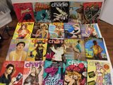 a lot of magazines on a table with a bottle of wine
