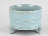 a small blue bowl sitting on a stand on a white surface
