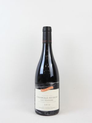 une bouteille de vin rouge posée sur une table blanche