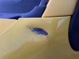 a yellow car that has a hole in the side of it