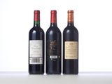 three bottles of wine are lined up on a table