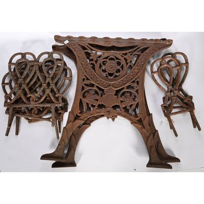 trois chaises anciennes en fonte et une table sur fond blanc