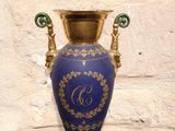 a blue and gold vase sitting on a black table