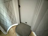 des toilettes situées dans un coin d'une salle de bains au sol en bois