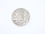 an old silver coin with a crown on it on a white surface