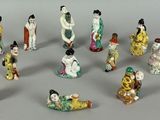 many figurines of asian women and men in a circle