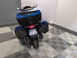 a blue motorcycle parked in a room with a checkered floor