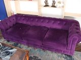 un canapé violet dans un salon aux murs bleus