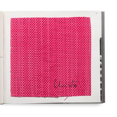 an open book with a picture of a pink piece of cloth on top of it