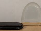 a small black object on a table next to a large clear object