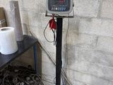 une image représentant une balance dans une pièce où se trouvent de nombreuses boîtes