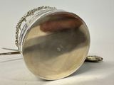a silver purse with a chain around it on a white surface