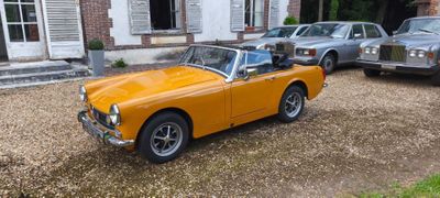 une voiture orange garée devant une maison
