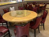 tables and chairs in a restaurant with a large painting on the wall